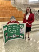 Rebecca Fassett poses at State with her presentation board. 